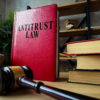 Antitrust law and stack of documents with gavel.