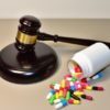 Mallet of judge and Multicolored pills in capsules in courtroom. Litigation Medicine-Related Healthcare in Pharmaceuticals. Justice concept. Judge hammer on law theme and legal system