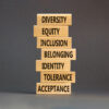 Diversity, inclusion symbol. Diversity belonging inclusion equity identity tolerance acceptance words on blocks. Beautiful grey table grey background. Diversity inclusion belonging concept.